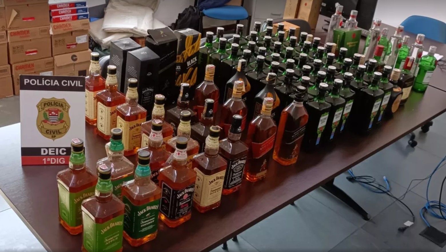 Garrafas de bebidas falsificadas apreendidas em mesa durante operação policial no Brasil