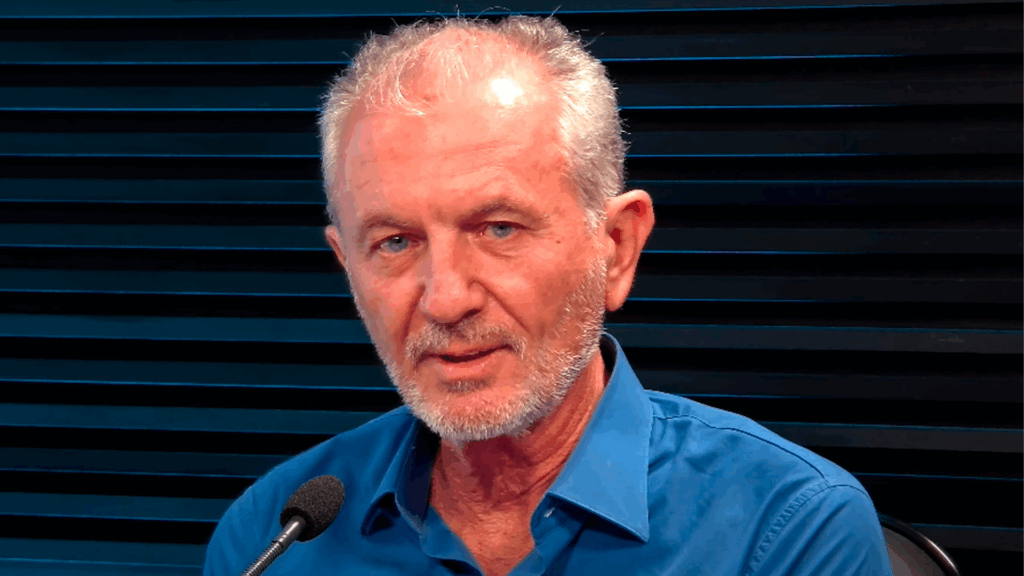 Homem falando diante de microfone em estúdio, durante gravação relacionada a tema político investigado pela PF.