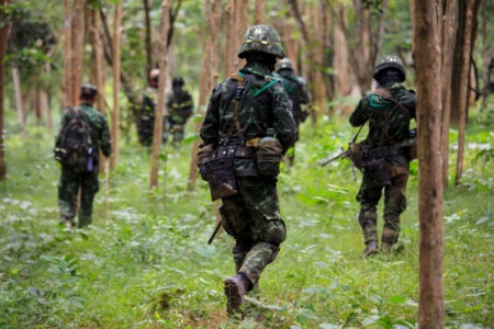 STJ decide que militares trans não podem ser afastados Militares camuflados caminham em formação por área de mata durante operação em terreno de floresta.
