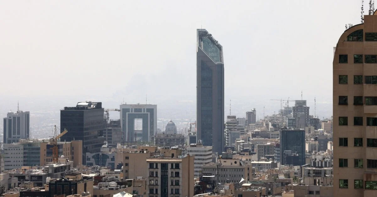 Vista aérea de Teerã mostrando prédios altos sob neblina e clima seco.