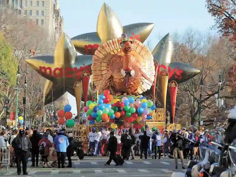 Balão gigante de peru inflável no desfile de Dia de Ação de Graças da Macy's em Nova York com multidão assistindo e balões coloridos
