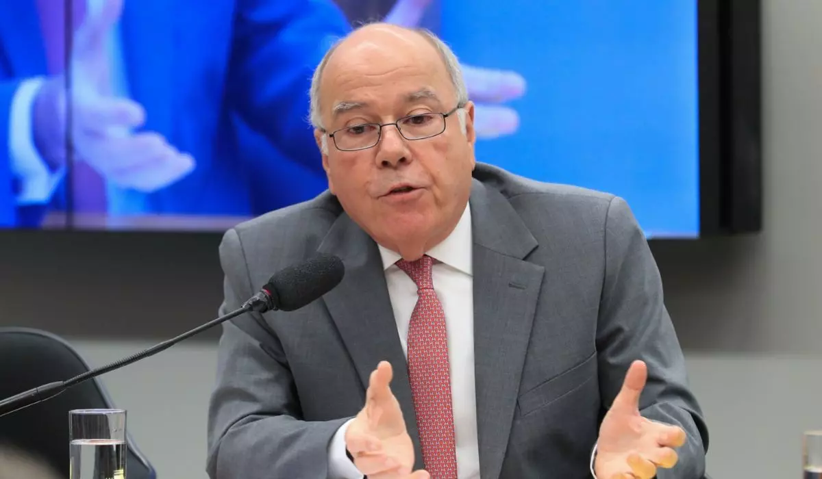 Mauro Vieira falando em audiência oficial, sentado à mesa, usando terno e gravata, diante de um microfone.