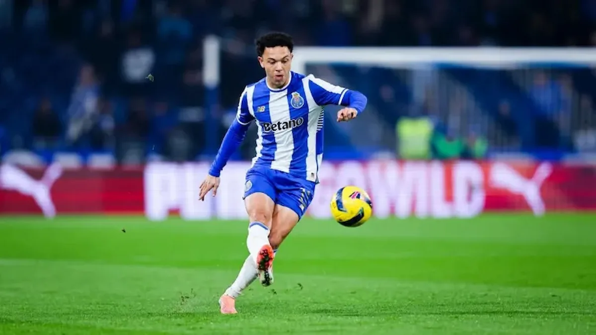 Pepê chutando bola em partida do Porto com uniforme azul e branco
