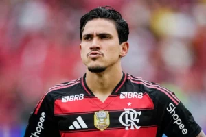 Pedro, atacante do Flamengo, com expressão séria, vestindo a camisa rubro-negra com o patch de campeão da Copa do Brasil de 2024.